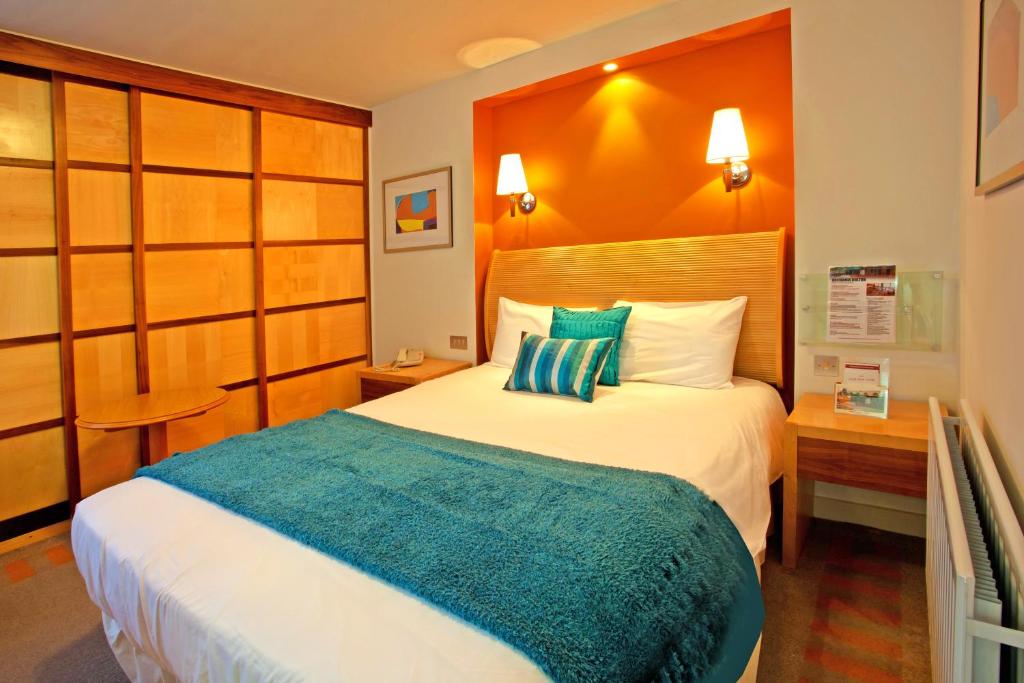 博尔顿大不列颠博尔顿酒店的酒店客房,配有一张带蓝色毯子的床