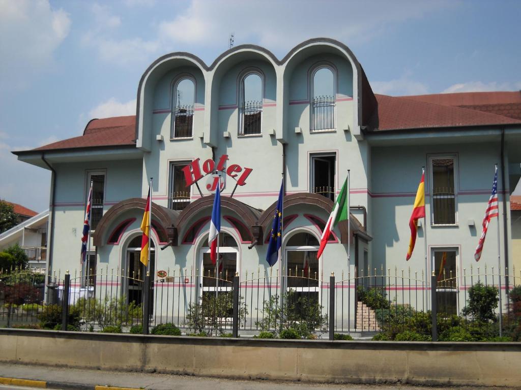 奥尔巴萨诺J酒店的前面有旗帜的建筑