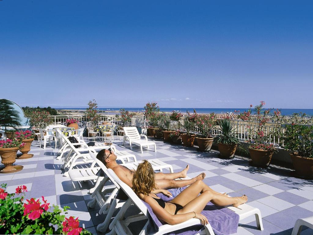 比比翁米拉马雷酒店的两名妇女在海滩上躺在躺椅上