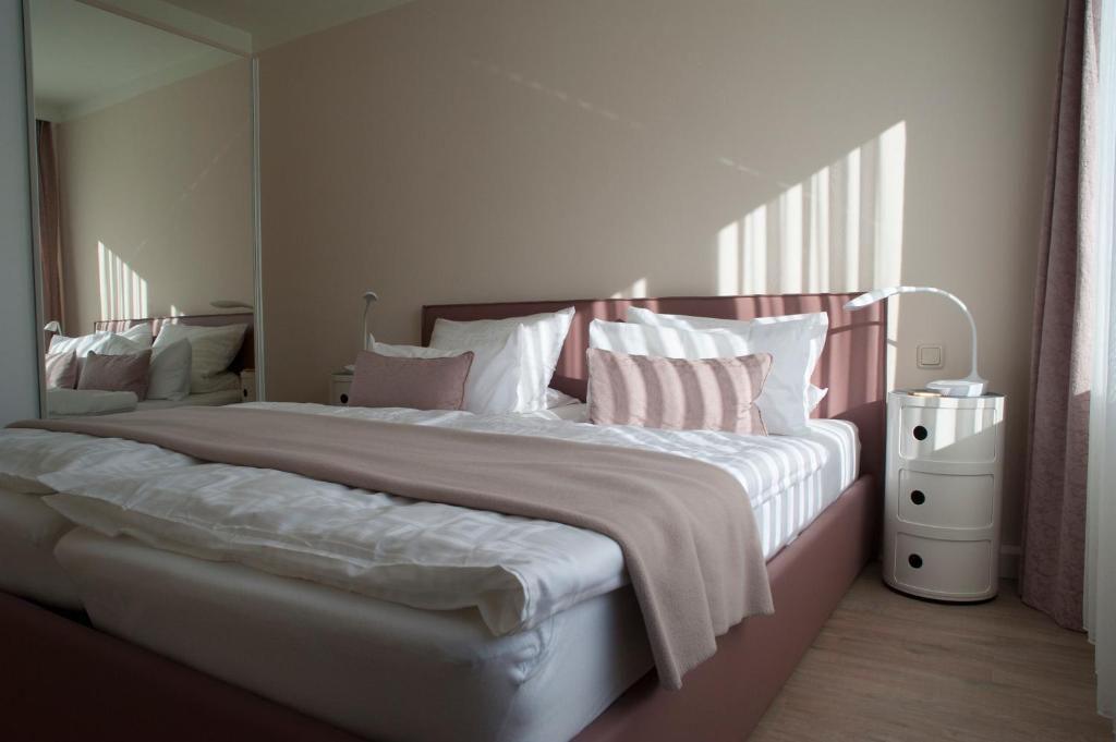 伊尔梅瑙Antoinettes Ferienwohnung的卧室配有带粉色和白色枕头的大床