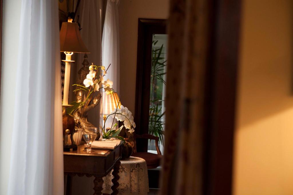 诺丁汉鲁丁顿住宿加早餐旅馆的一间设有鲜花和台灯的桌子的房间