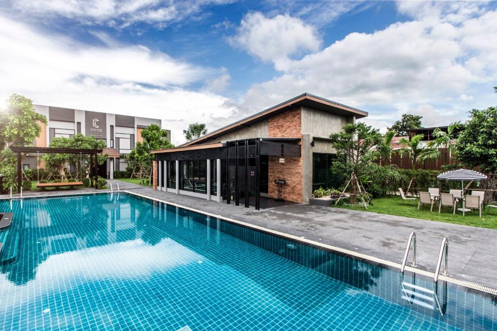武里南Cresco Hotel Buriram的房屋前游泳池的图像