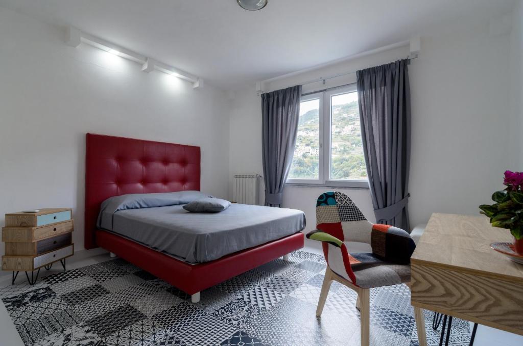 拉维罗Rosa e Valentino的一间卧室配有红色的床、一张桌子和一把椅子