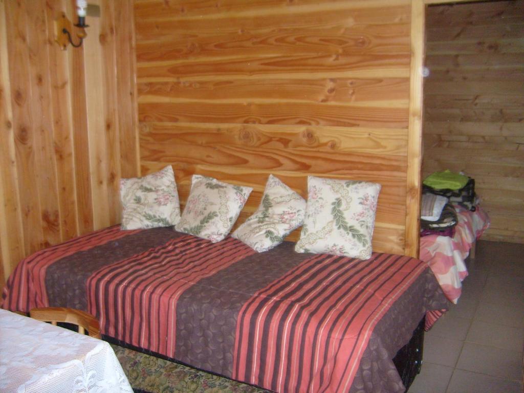 里坎雷Cabañas Los Castaños的一间卧室设有一张床和木墙