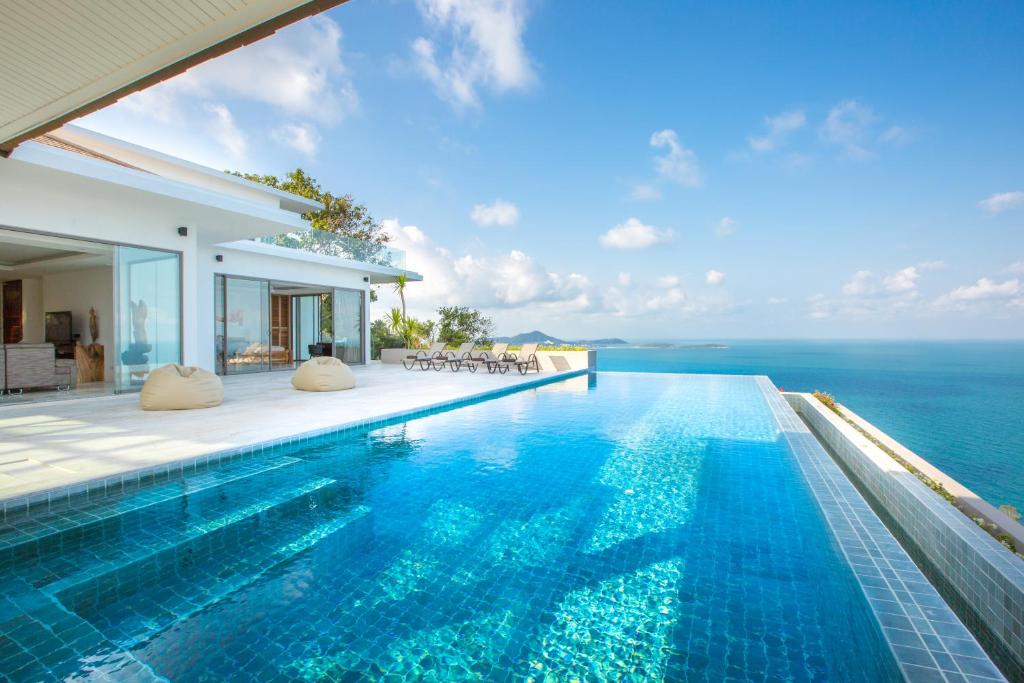 查汶BelVillas-Award Winning SeaView Luxury Villas的一座位于别墅内的无边游泳池,别墅的背景是大海