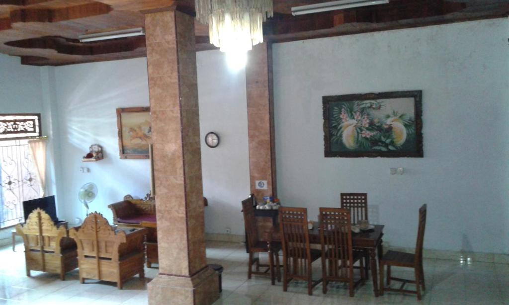 登巴萨巴厘岛瑞提旅舍的一间带桌椅和柱子的用餐室