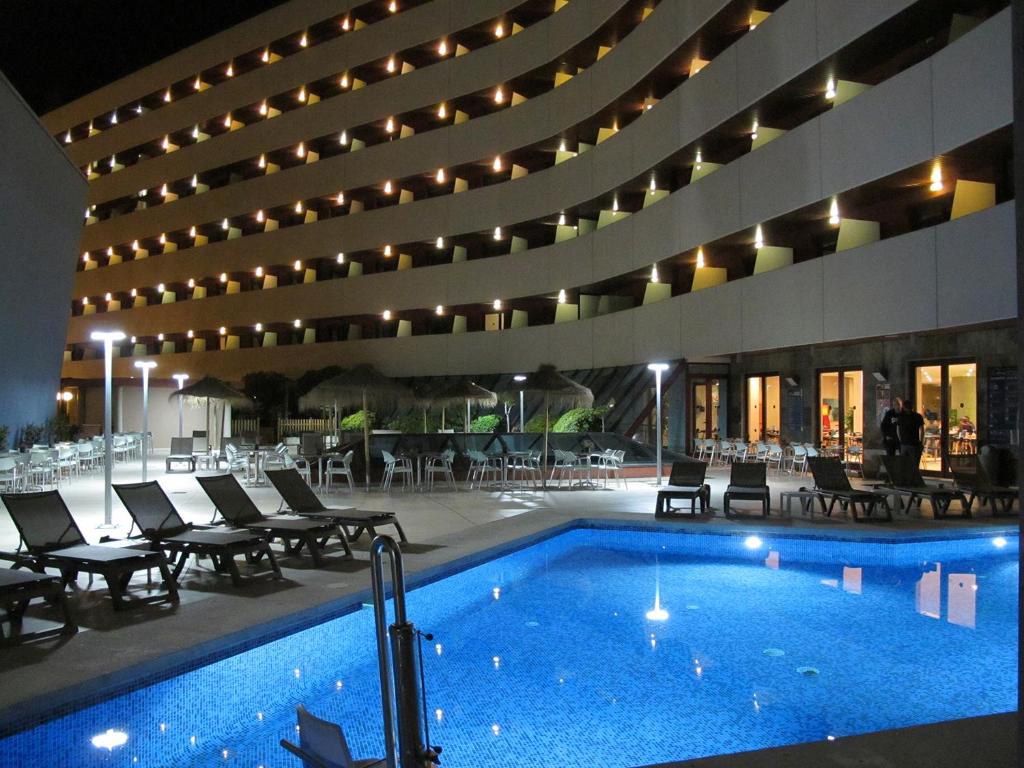 拉利内阿-德拉康塞普西翁直布罗陀坎波欧特斯酒店的一座带游泳池和椅子的酒店和一座建筑