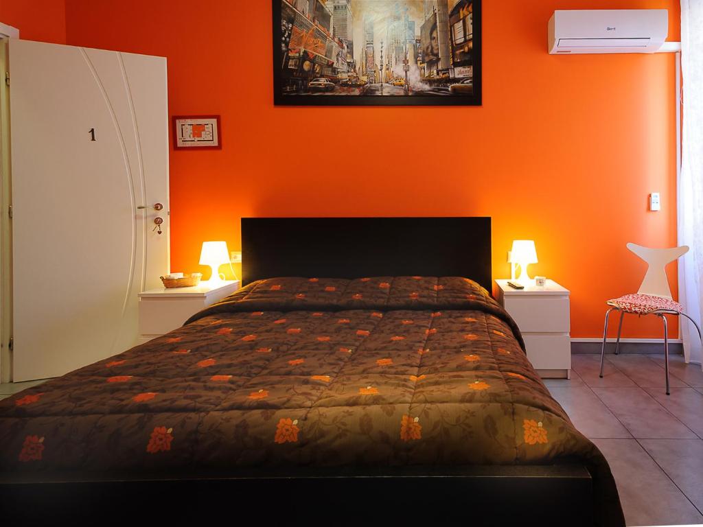 钱皮诺亚得里亚罗姆酒店的一间卧室配有一张橙色墙壁的床
