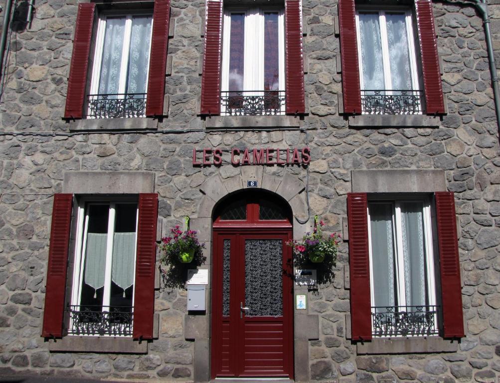 勒蒙多尔莱斯卡姆利阿斯酒店的一座石头建筑,设有红色的门窗