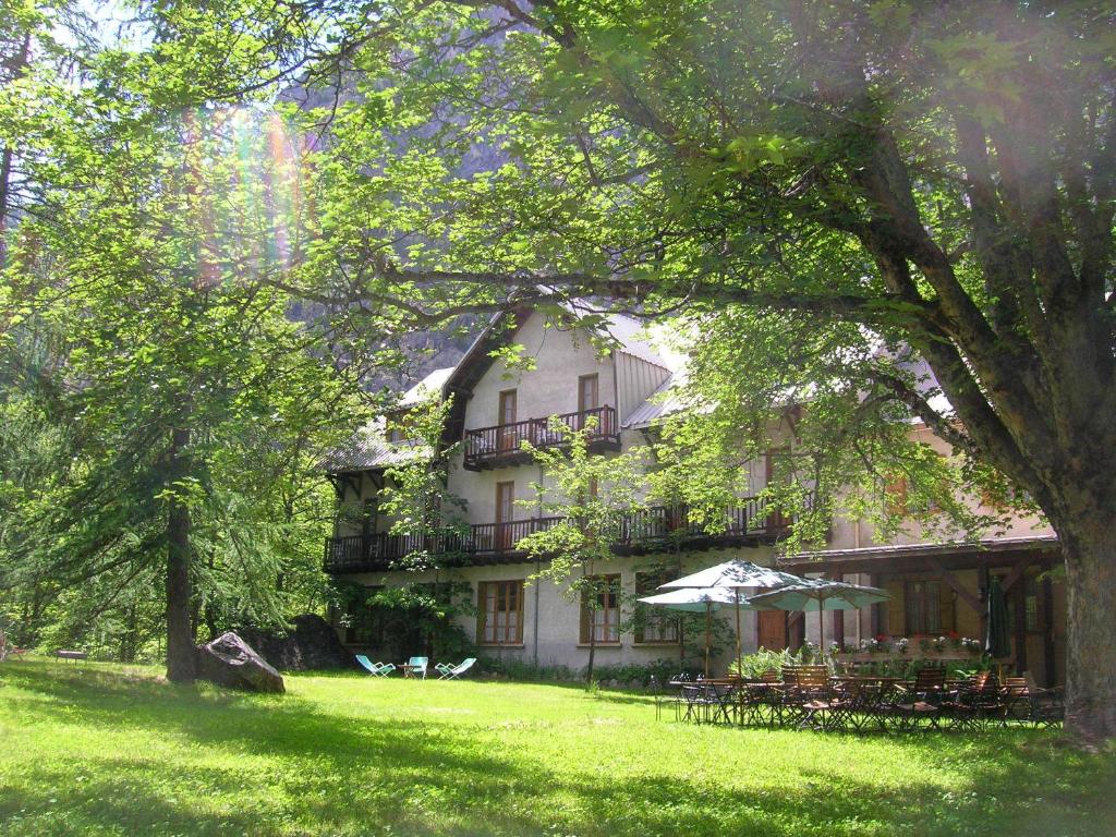 艾勒弗魯瓦德黛勒夫瓦德别墅酒店​​的一座白色的大建筑,在草地上摆放着桌椅