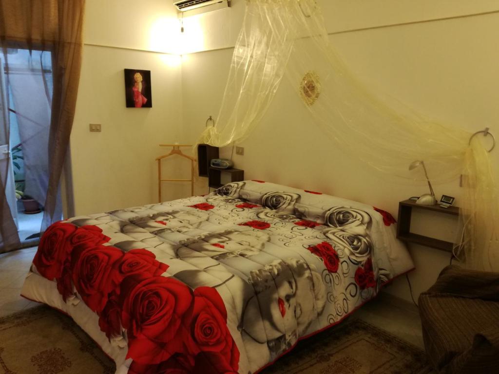 Collemetoterra e mare的一间卧室,床上有红色玫瑰