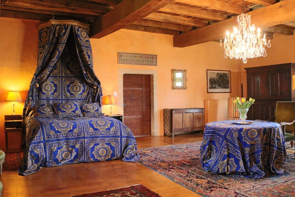 沙尔略马法勒庄园酒店的一间卧室配有一张带桌子和吊灯的床。