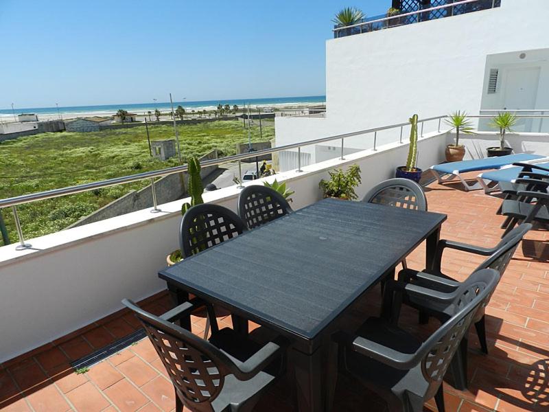 科尼尔-德拉弗龙特拉Casitasmanoli Conil的海滩阳台的一张黑桌子和椅子