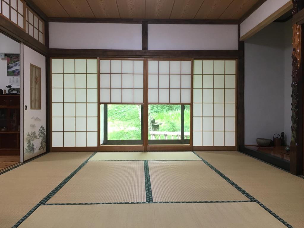 上田市安苏西田度假屋的客房设有大窗户 和瓷砖地板。