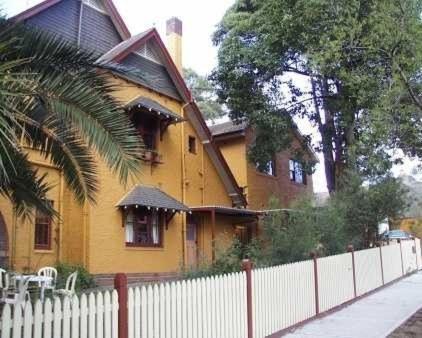 悉尼伯伍德住宿加早餐酒店的前面有栅栏的黄色房子