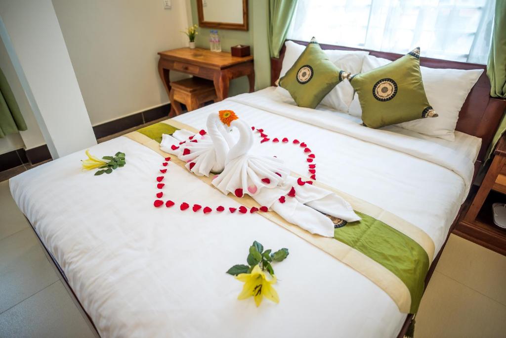 金边NKS酒店的一间卧室配有一张带天鹅装饰的床。