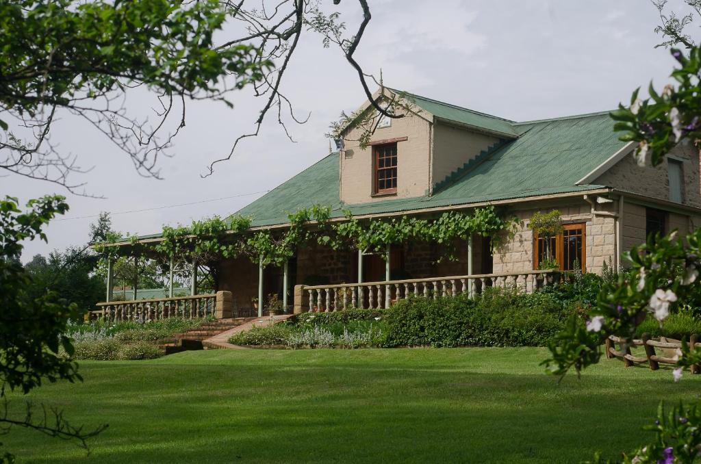 霍维克Halliwell Country Inn的一座带绿色屋顶和庭院的房子