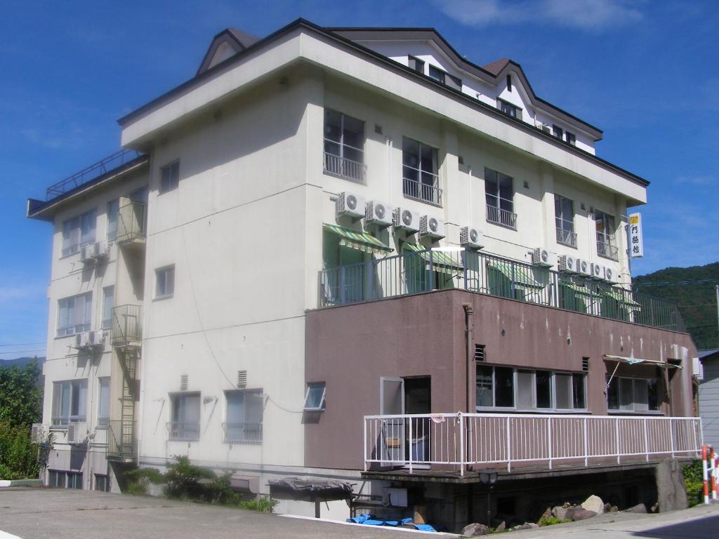 野沢卡多瓦几馆酒店的带阳台的大型白色建筑