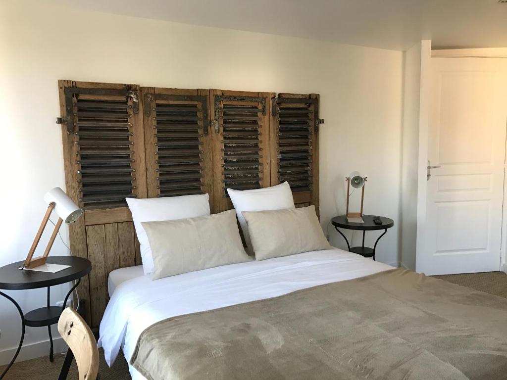 CleppéO Lodge的卧室配有一张带两张桌子的大型白色床