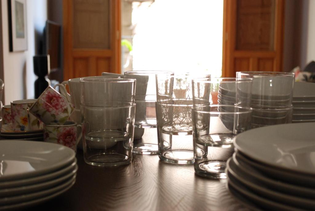 瓦伦西亚Lonja Valencia Flats的一张木桌,上面有玻璃杯和盘子