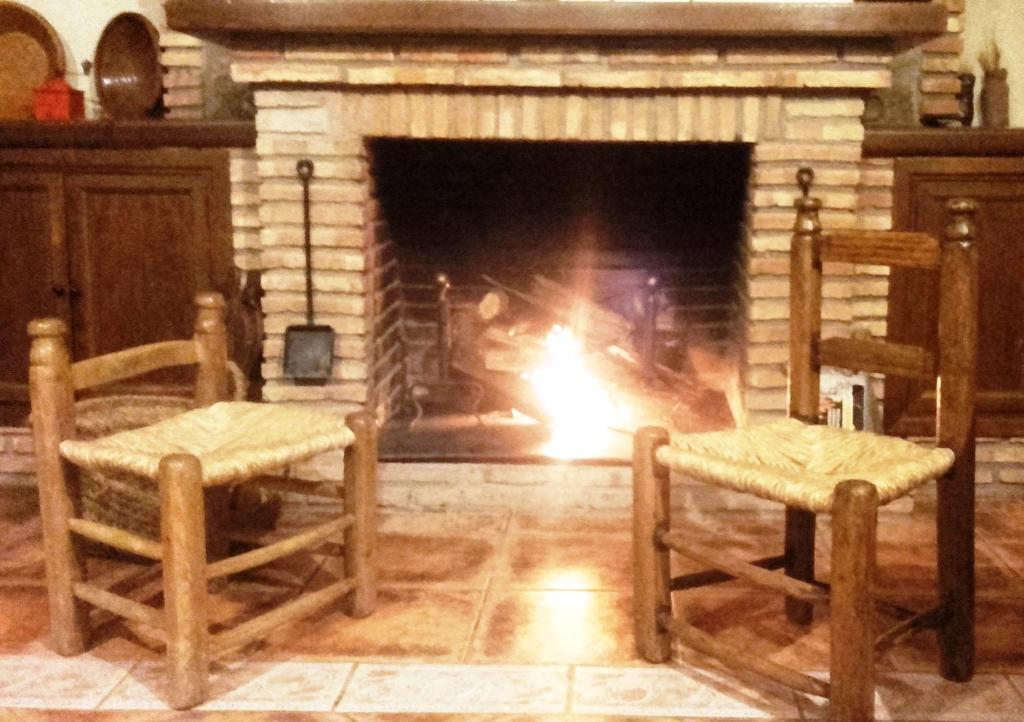 托雷洪厄尔卢比奥法尔孔佩尼亚卡萨乡村酒店的壁炉前设有两把椅子和壁炉