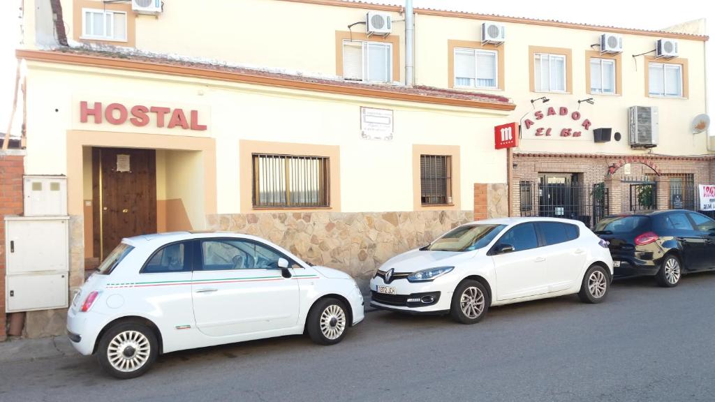 塞塞尼亚Hostal Seseña的停在酒店门前的两辆白色汽车