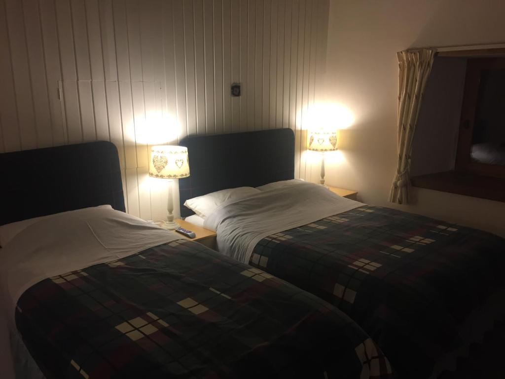 斯特灵山景小屋酒店的配有2盏灯的酒店客房的2张床