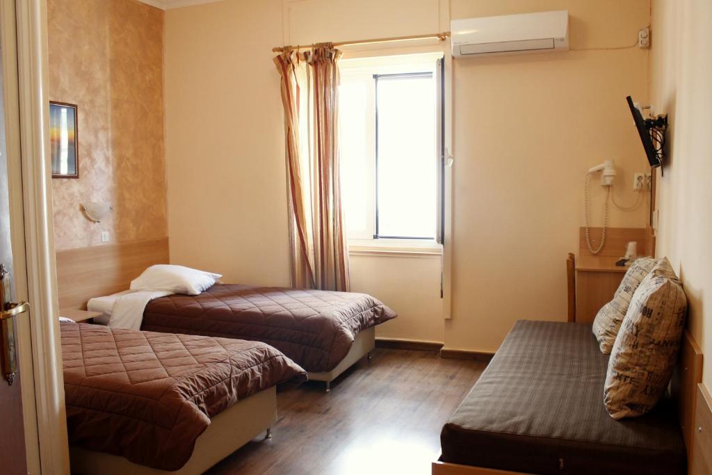 比雷埃夫斯伊莱克特拉比雷埃夫斯酒店的小房间设有两张床和窗户