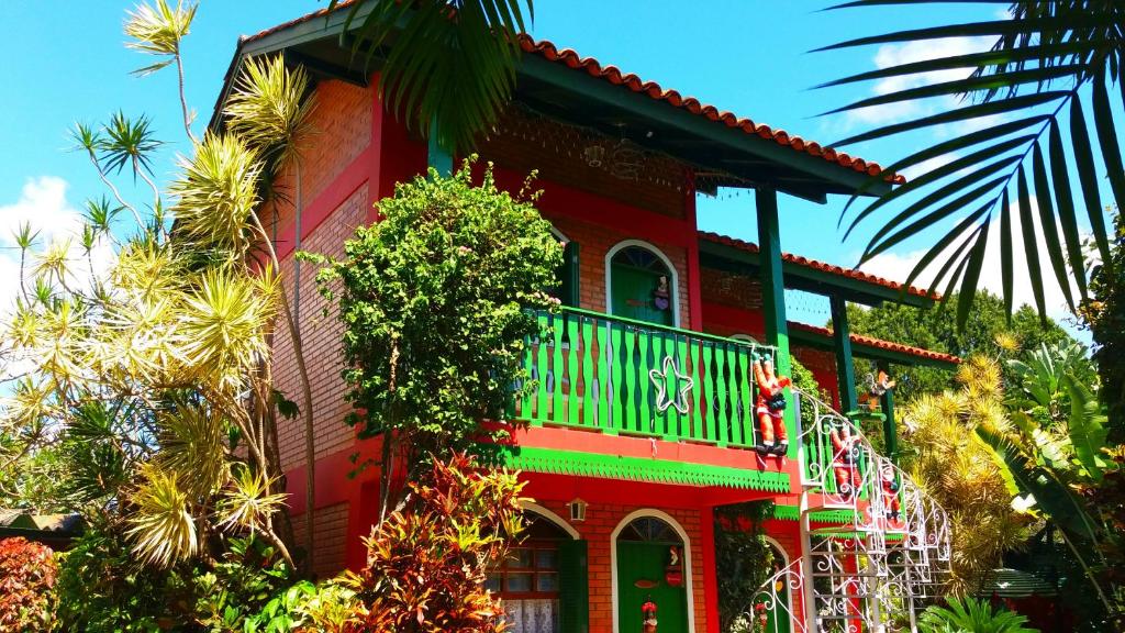 弗洛里亚诺波利斯Pousada Estrela do Mar的一间红色的房子,旁边设有阳台