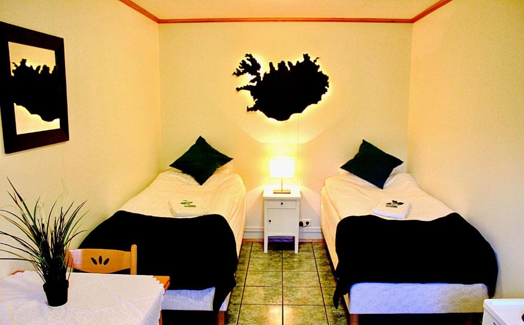 韦斯特曼纳埃亚尔奥尼住宿加早餐旅馆的客房设有两张床、一张桌子和一盏灯。