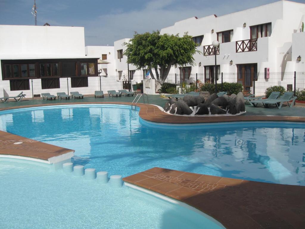 科拉雷侯La Graciosa Apartment的一座大游泳池,在一座建筑前设有三只熊雕像