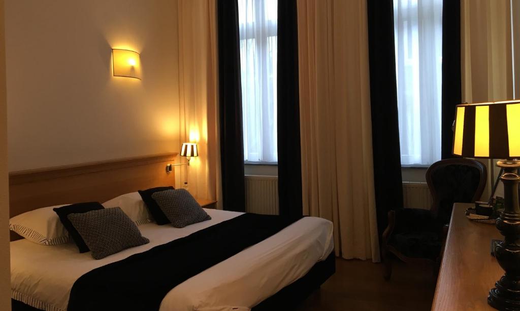 马斯特里赫特瑞考查播得酒店的酒店客房设有一张床、一张书桌和窗户。