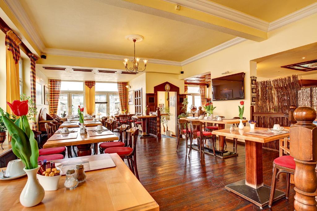 代特莫尔德代特莫尔德斯塔德特酒店的餐厅设有木桌和红色椅子