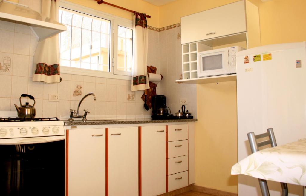 玛德琳港Complejo Andalhue的厨房配有白色橱柜和白色冰箱。