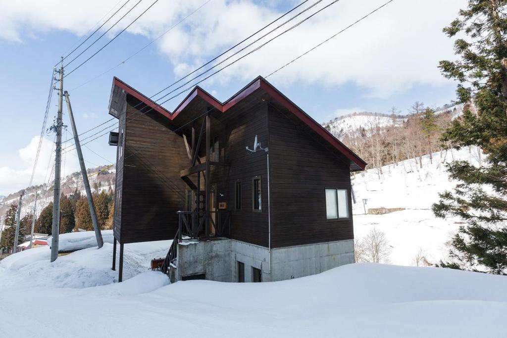 野沢野泽豪斯酒店的雪中的小木屋