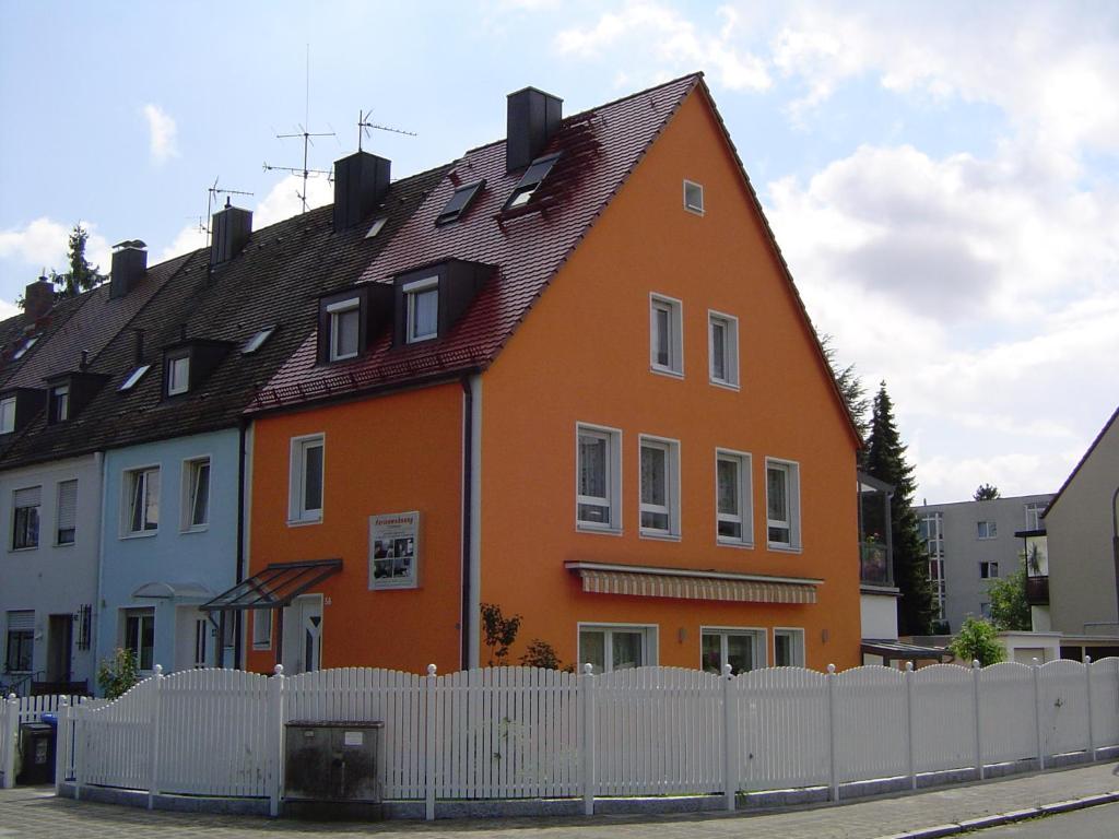 纽伦堡古曼度假公寓的白色围栏后面的一座大型橙色房子