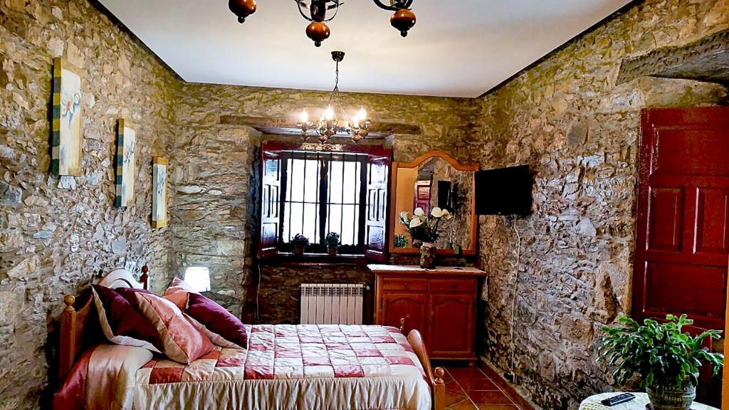 FaedoLa Casona de Faedo Pensión的一间卧室设有一张床和石墙