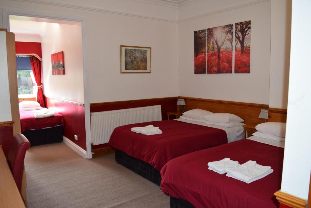 巴尔内特黑斯尔班克旅馆的酒店客房,配有两张带红色床单的床
