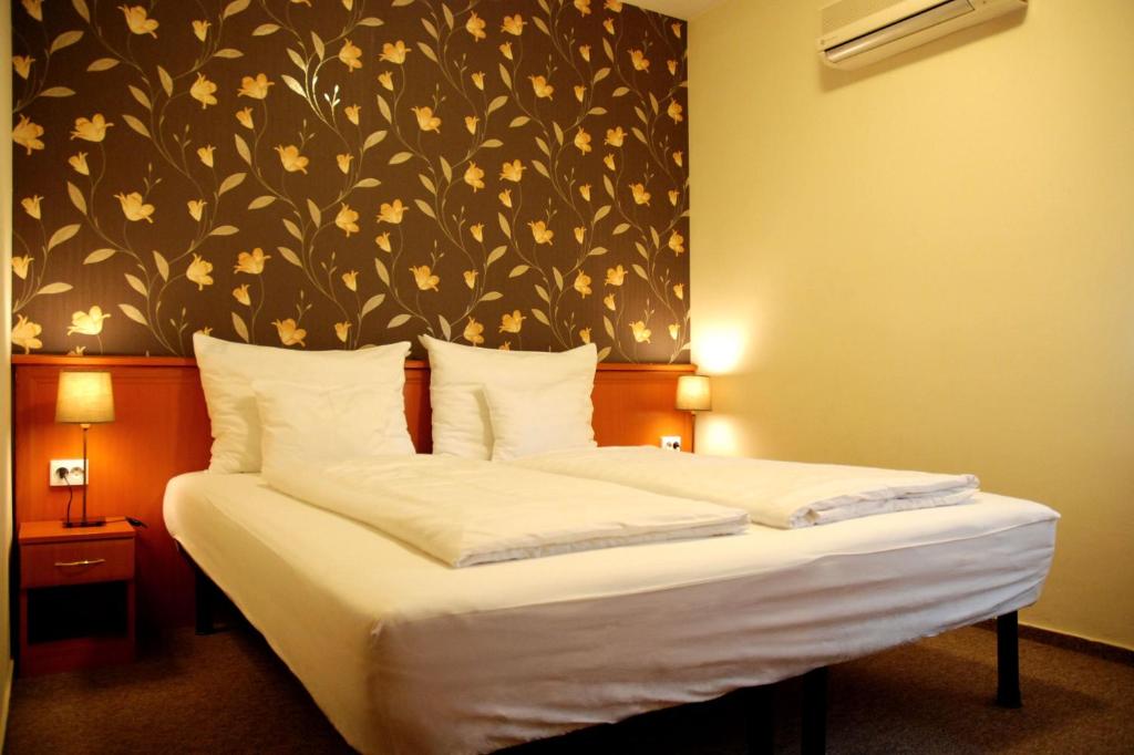 佩奇柯尼希酒店的一间卧室配有一张带花卉壁纸的床