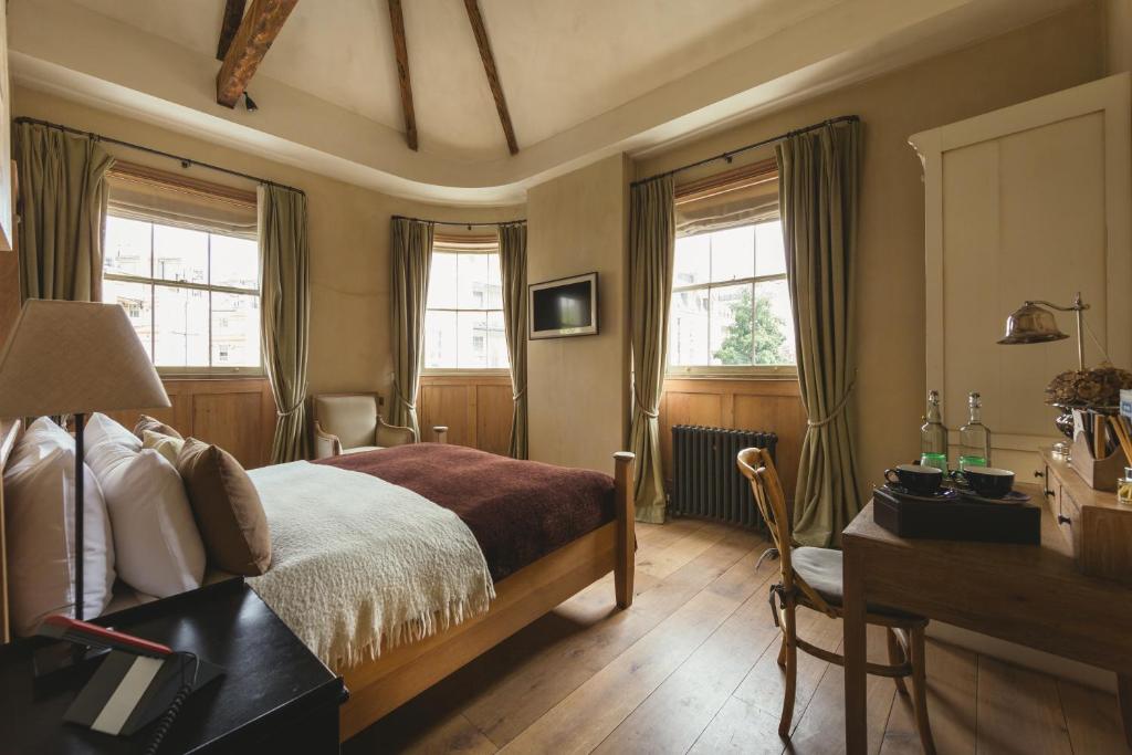 伦敦橙子酒店的卧室配有一张床、一张书桌和窗户。