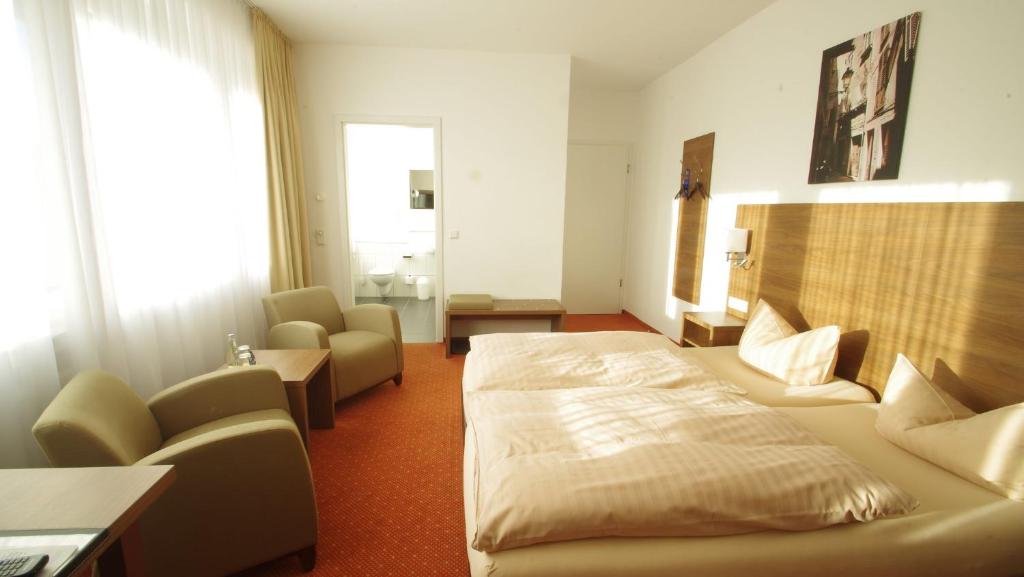富尔达曼德法赫特皮特彻斯酒店的配有一张床和一把椅子的酒店客房