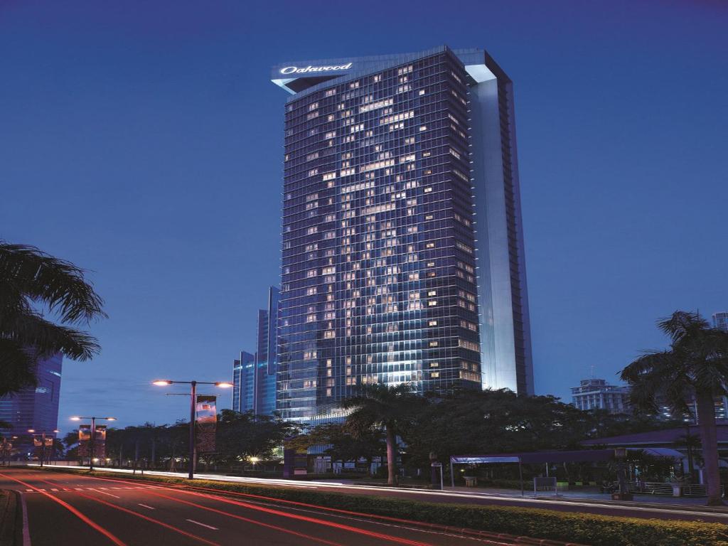雅加达雅加达 Cozmo 奥卓豪景酒店公寓的一座高大的建筑,上面有沙姆星标志