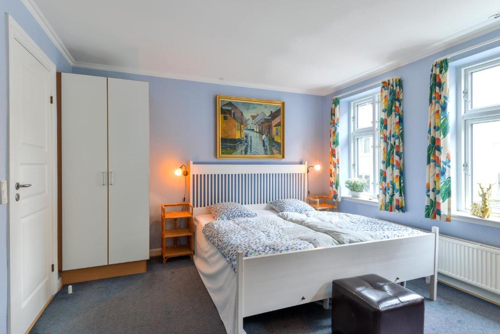 维堡Viborg City Rooms的一间卧室配有一张蓝色墙壁和窗户的床