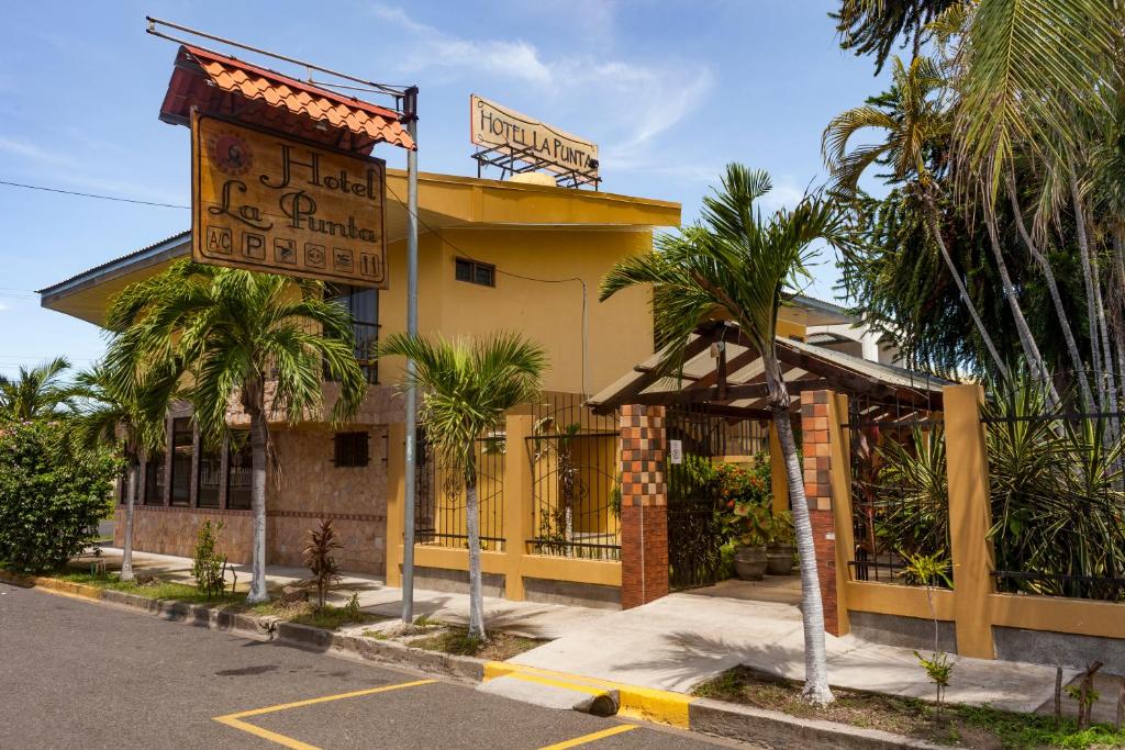 蓬塔雷纳斯Hotel La Punta的黄色的建筑,前面有标志