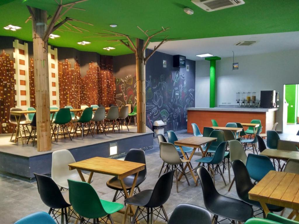 马德里Motion Chueca Hostel的一间带桌椅的餐厅以及绿色天花板