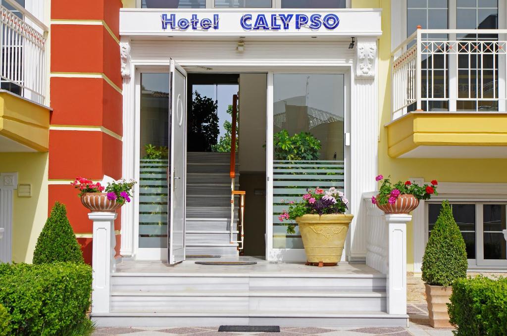 帕拉利亚卡泰里尼斯Calypso Beach Hotel的酒店大堂设有楼梯,盆栽有鲜花