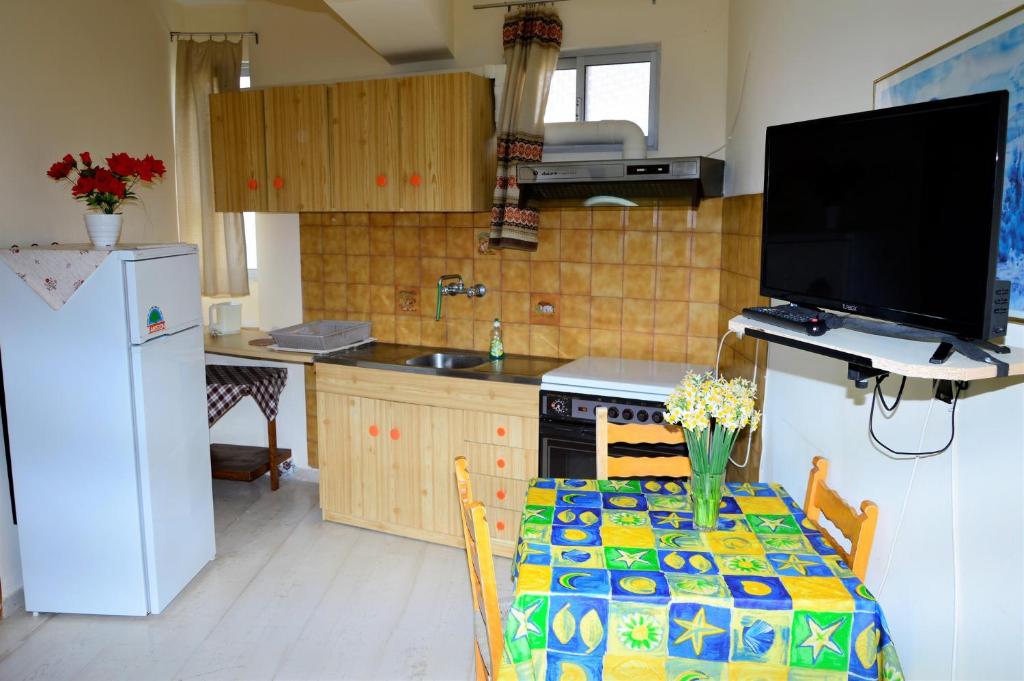 波罗斯Pantelis的厨房配有桌子、电视和冰箱