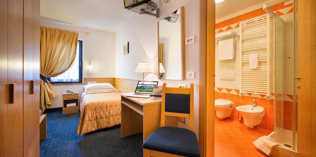 佩约方缇克丽斯塔罗酒店的酒店客房配有一张床、一张书桌和一台笔记本电脑