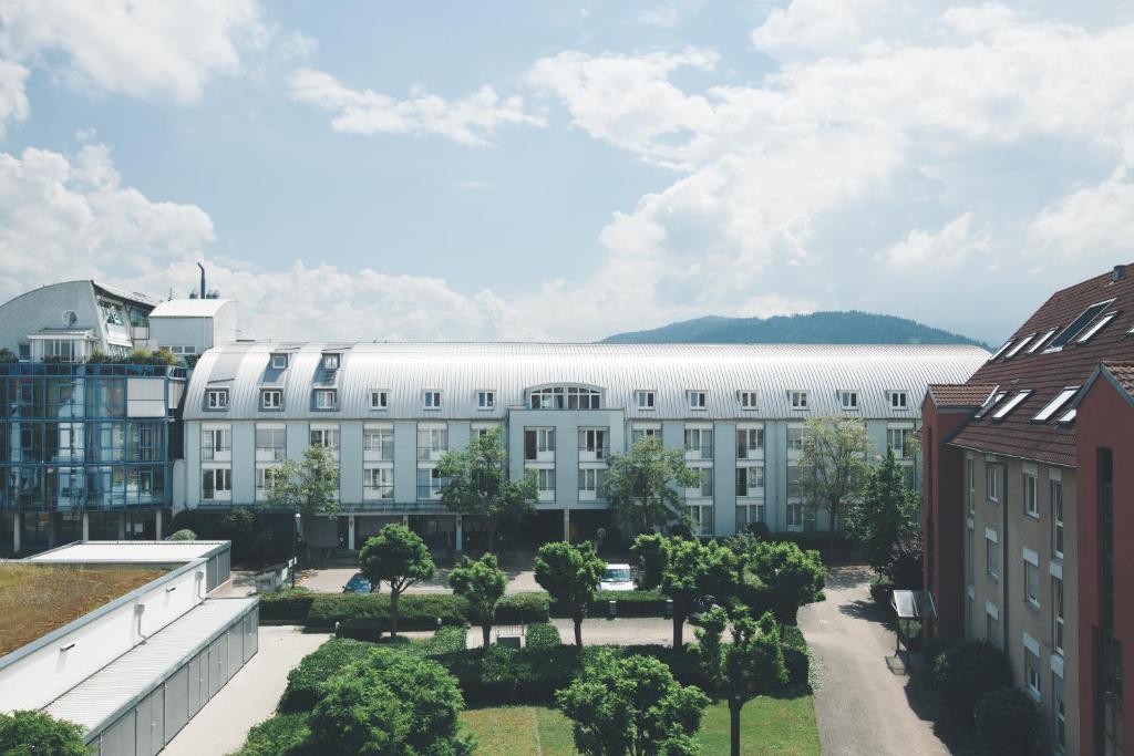 弗莱堡施泰因旅馆招待所的一座白色的大建筑,在庭院里种有树木