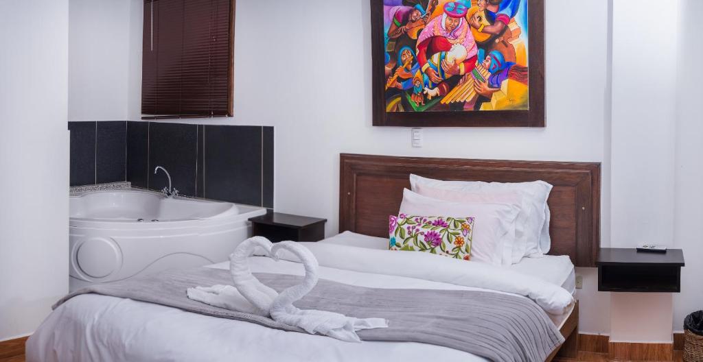 马丘比丘塔雅塔宾馆的卧室配有1张床、浴缸和水槽。